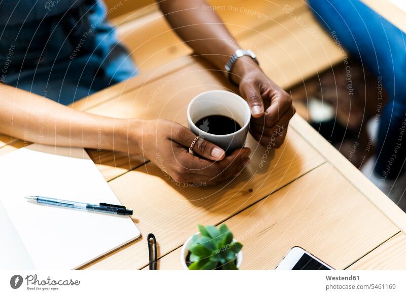 High angle view of woman holding black coffee at table in cafe color image colour image indoors indoor shot indoor shots interior interior view Interiors day