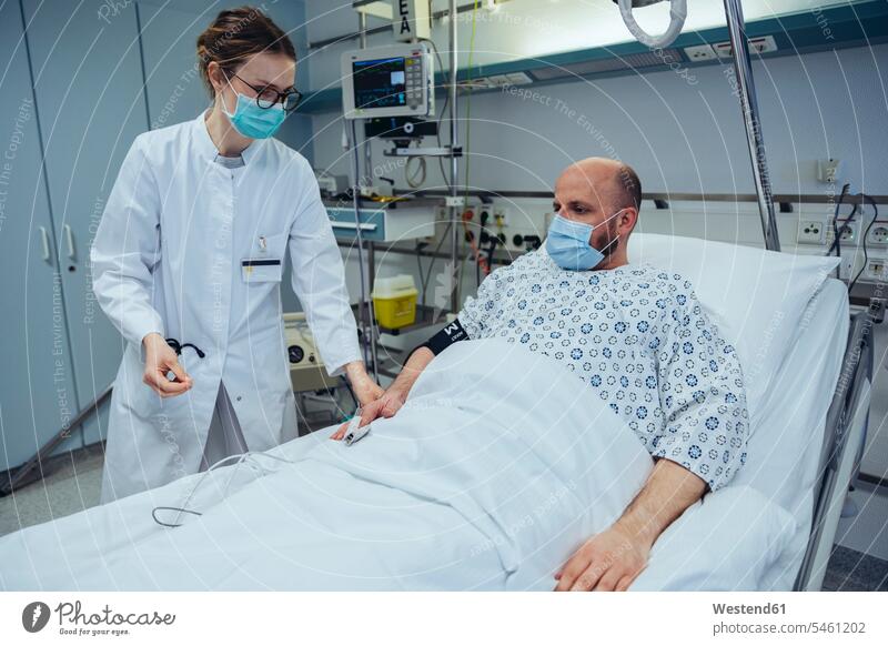 Doctor connecting patient to pulse tracer in hospital room health healthcare Healthcare And Medicines medical medicine disease diseases ill illnesses sick