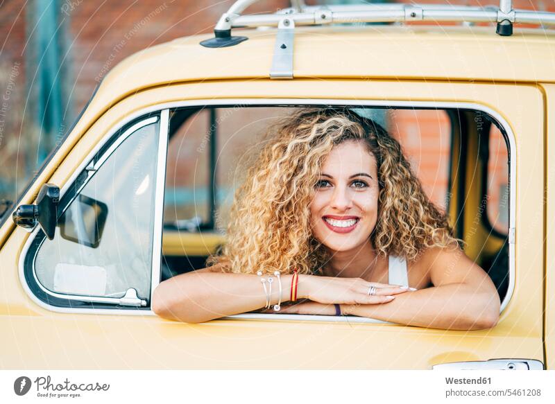 Portrait of happy blond woman looking out of window of classic car females women view seeing viewing happiness portrait portraits car window car windows