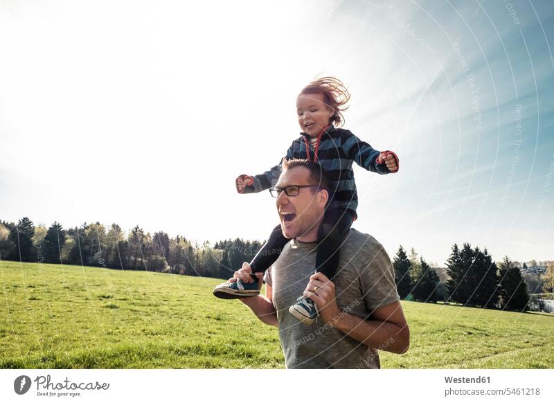 Portrait of father carrying little daughter on his shoulders seasons spring season Spring Time springtime delight enjoyment Pleasant pleasure country