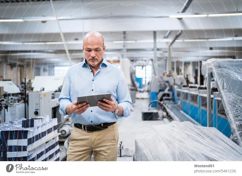Businessman using tablet in a factory Occupation Work job jobs profession professional occupation business life business world business person businesspeople