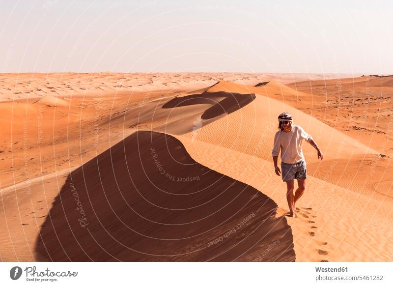 Man walking on a sand dune, Wahiba Sands, Oman go going stand free Liberty on the go on the road on the way sandy skies landscapes scenery terrain Deserts dunes