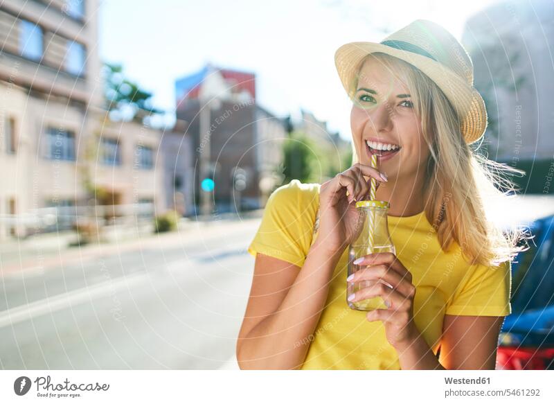Happy young woman enjoying a drink in the city human human being human beings humans person persons caucasian appearance caucasian ethnicity european 1