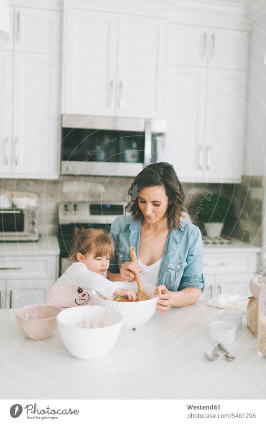 Mother and daughter making a cake together assistance assisting Help helping kitchen domestic kitchen kitchens pies cakes dough mother mommy mothers mummy mama