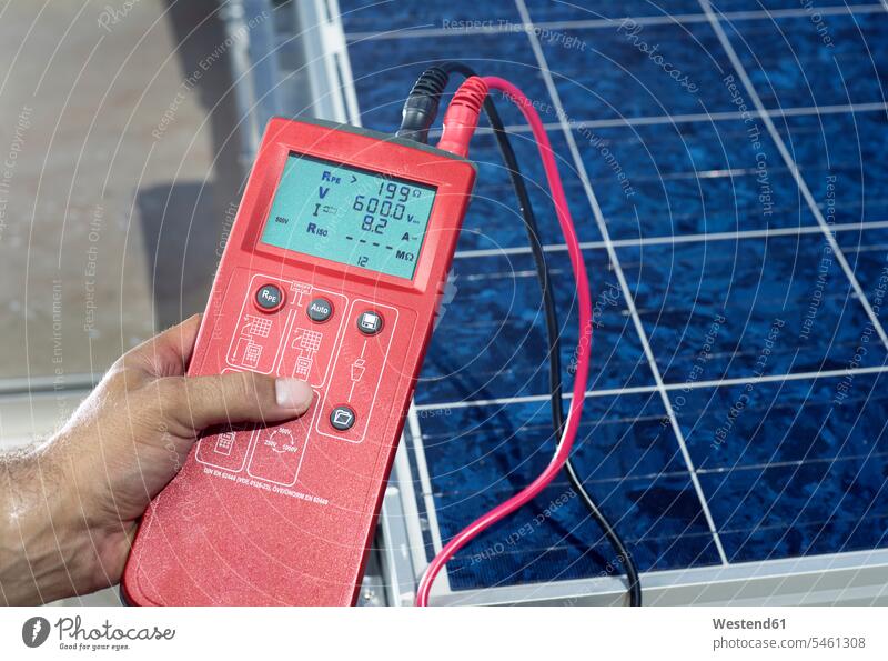 Man's hand holding measuring device in front of solar plant, close-up human hand hands human hands measuring instruments measuring devices
