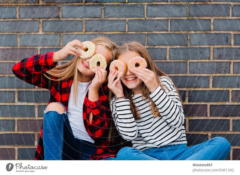 Two girls having fun with doughnuts donuts Doughnuts Fun funny females Pastry Pastries Sweet Food sweet foods food and drink Nutrition Alimentation