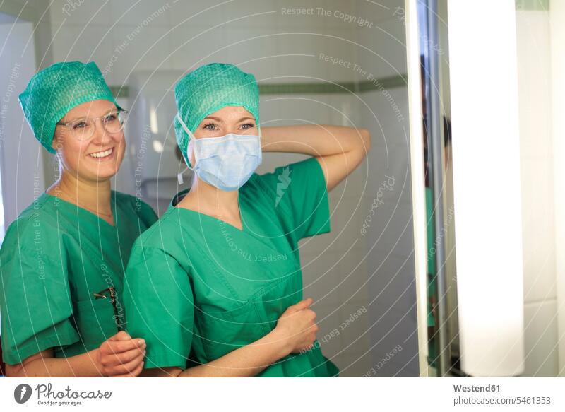 Two smiling women in scrubs preparing for a surgery health healthy Dedication Engagement dedicated Eager Input eagerness Commitment surgeries operating