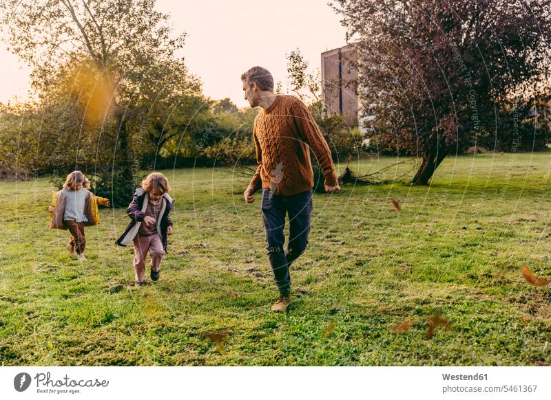 Father running with daughters on a meadow in autumn human human being human beings humans person persons caucasian appearance caucasian ethnicity european Group