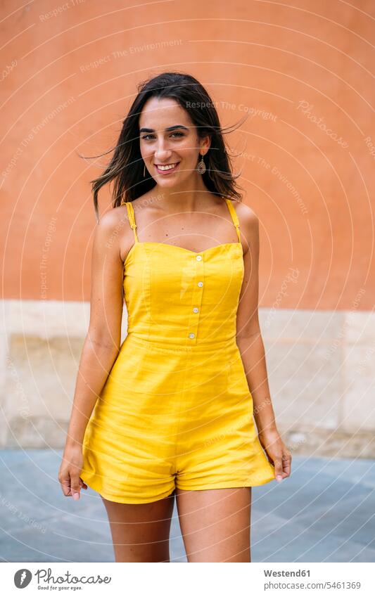 Portrait of beautiful young woman in yellow dress dark-haired brown haired brunette smile seasons summer time summertime summery delight enjoyment Pleasant