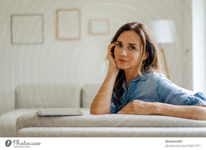 Portrait of mature woman resting on couch at home couches settee settees sofa sofas portraits human human being human beings humans person persons adult