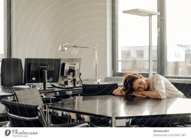 Tired businesswoman sleeping on her desk tired napping Naptime businesswomen business woman business women sitting Seated asleep lying laying down lie