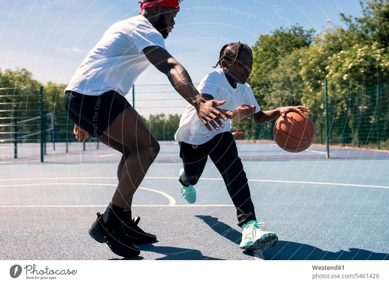Father and son playing basketball on basketball court balls exercise practising train training free time leisure time Recreational Activities