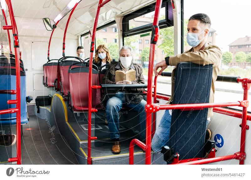 Passengers wearing protective masks in public bus, Spain books transport motor vehicles road vehicle road vehicles buses busses read travel traveling mobile