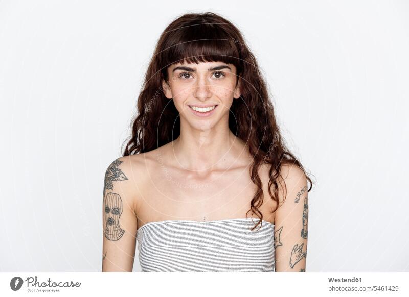Portrait of smiling young woman with freckles and tattoos on her upper arms smile off shoulder bare shoulders strapless word words western script