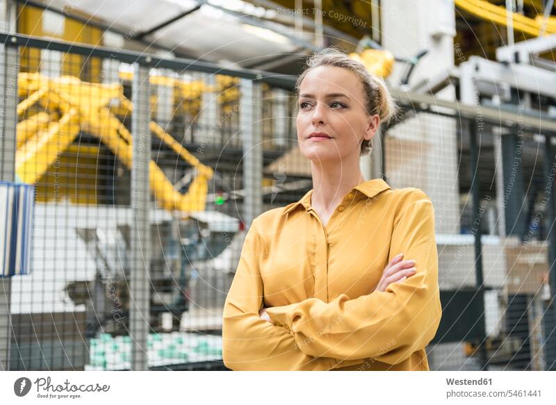 Portrait of confident woman in factory shop floor with industrial robot females women Self-confidence self-confident poised Self-Assured Self-Assurance portrait