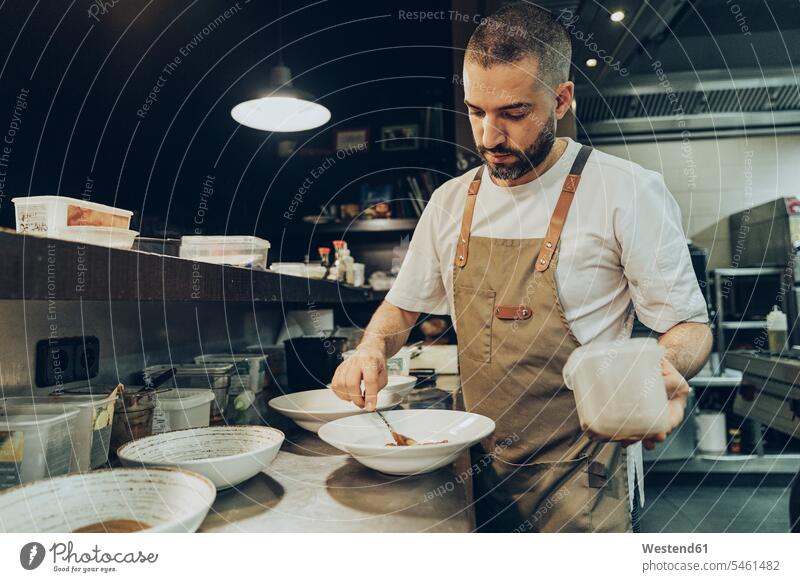 Chef arranging food on plate before serving in restaurant Occupation Work job jobs profession professional occupation Chefs cook cooks Crockery Tableware dish