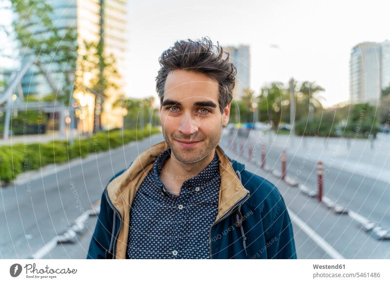 Portrait of smiling casual man in the city, Barcelona, Spain coat coats jackets smile in the evening pleased Distinct individual location shot location shots