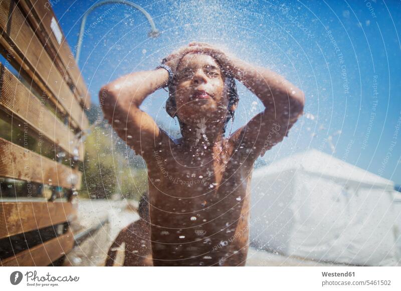 Little boy taking shower on the beach showers showering beaches childhood hand on head hands on head cooling Cool Down cooling down copy space