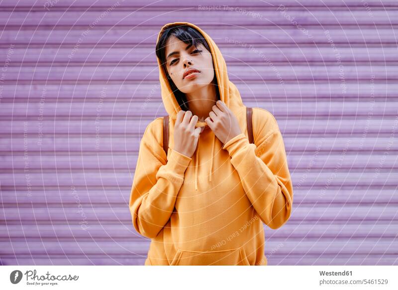 Portrait of young woman with yellow hoodie in front of purple background human human being human beings humans person persons 1 one person only only one person