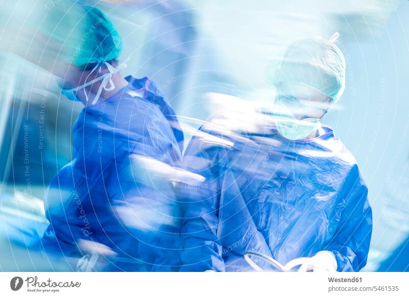 Male doctors doing surgery in operating room at hospital color image colour image indoors indoor shot indoor shots interior interior view Interiors front view