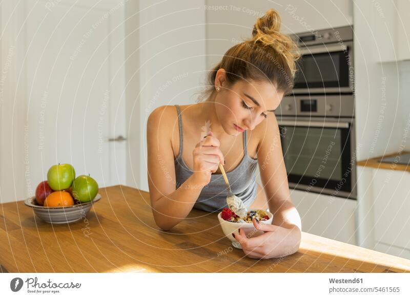Female teenager during breakfast in the kitchen Bowls in the morning hunger bored boring at home free time leisure time Distinct individual Alimentation food