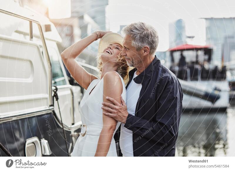 Older man and young woman at a marina next to a yacht Yacht Yachts couple twosomes partnership couples vessel water vehicle people persons human being humans