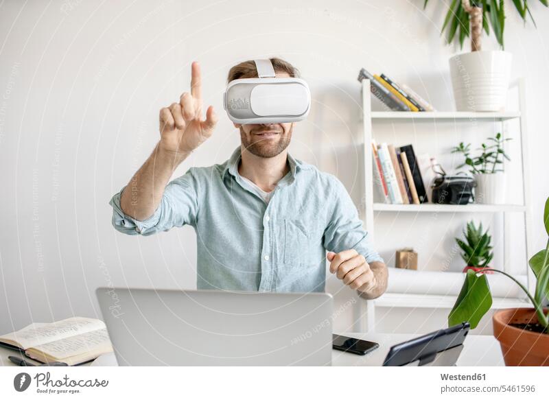 Man wearing VR glasses at desk in office Occupation Work job jobs profession professional occupation business life business world business person businesspeople