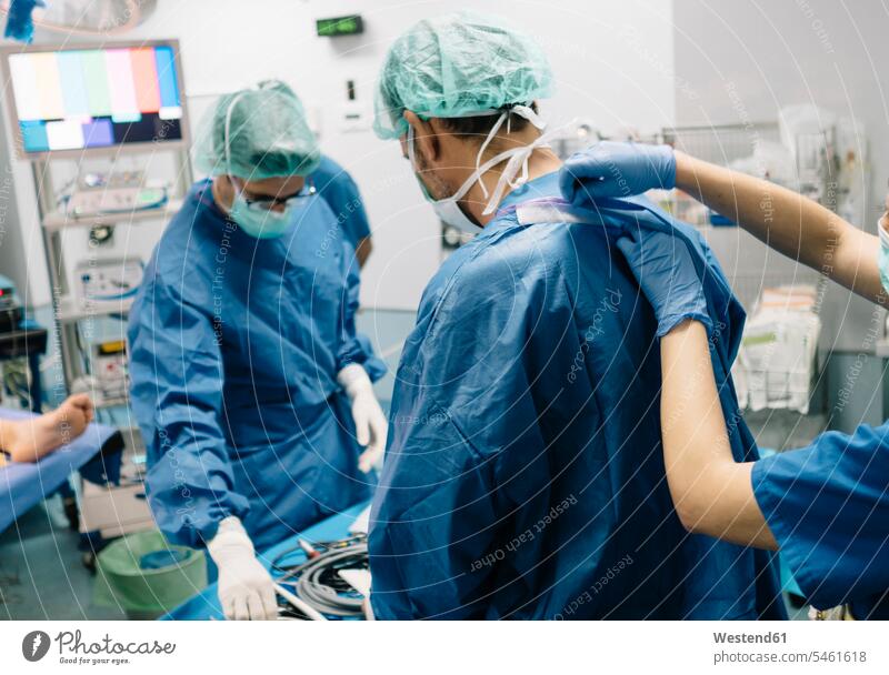 Female doctor helping orthopedic surgeon in operating room at hospital color image colour image indoors indoor shot indoor shots interior interior view