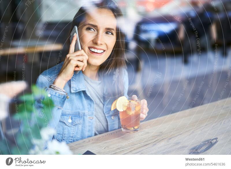 Smiling young woman on the phone drinking tea in cafe Tea Teas mobile phone mobiles mobile phones Cellphone cell phone cell phones females women smiling smile