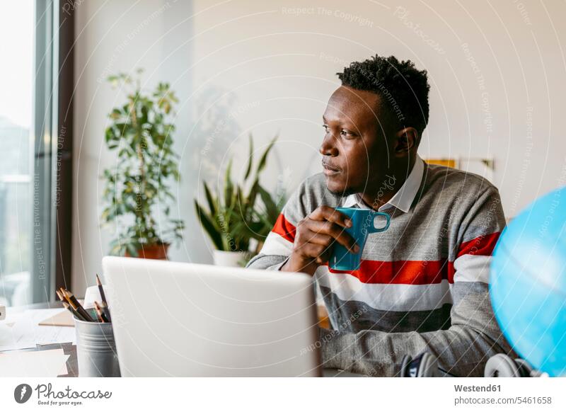 Thoughtful businessman looking away while sitting coffee cup at home color image colour image indoors indoor shot indoor shots interior interior view Interiors