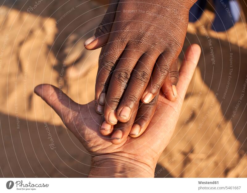 Black hands shaking white hands. Mucubal tribe, Tchitundo Hulo, Angola handshaking shake hands traditional Traditions contrasting Contrasts opposite opposites