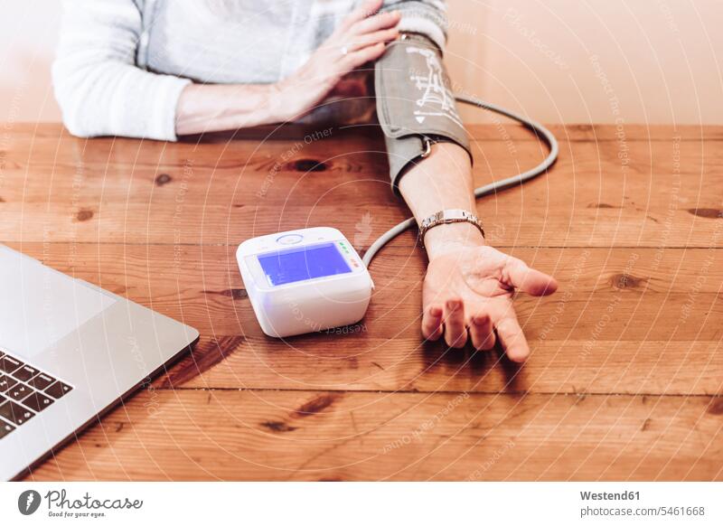 Senior woman checking blood pressure at home color image colour image indoors indoor shot indoor shots interior interior view Interiors Spain