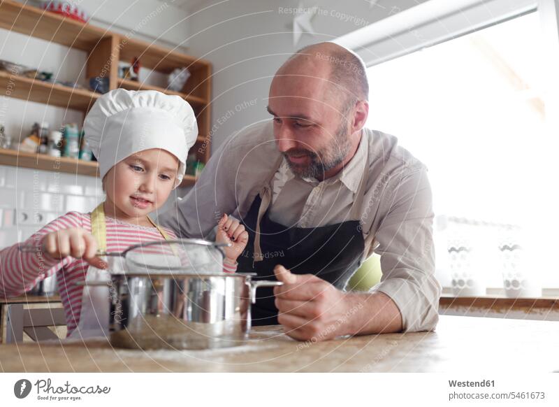 Father and daughter cooking in the kitchen Cooking Pots help smile delight enjoyment Pleasant pleasure happy passionate Contented Emotion pleased at home
