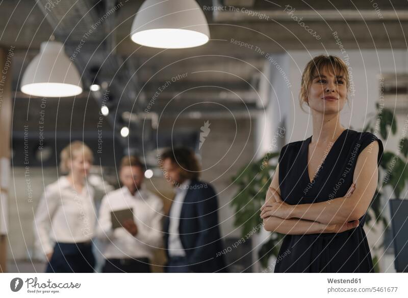 Portrait of confident businesswoman in office with colleagues in background Occupation Work job jobs profession professional occupation business life