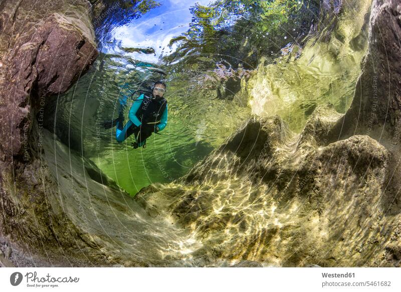 Austria, Salzkammergut, river Weissenbach, female scuba diver in a wild mountain river diving goggles diving suit diving suits wetsuit wet suit wetsuits