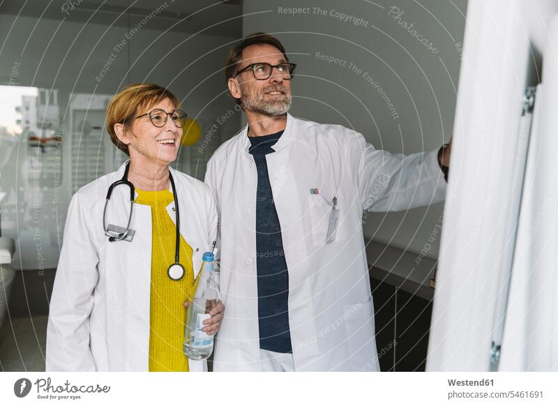 Two doctors discussing at smart board Occupation Work job jobs profession professional occupation health healthcare Healthcare And Medicines medical medicine