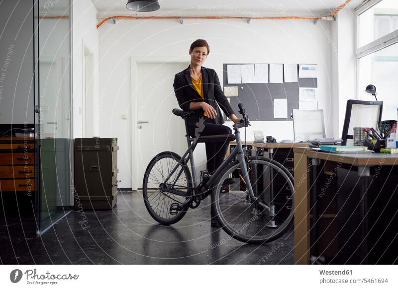 Businesswoman with bicycle in her start-up company business founder business founders female business founders businesswoman businesswomen business woman