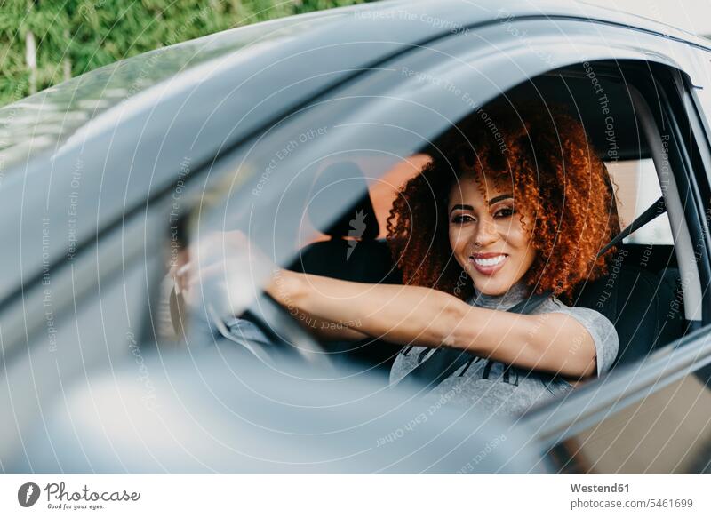 Smiling young woman with afro hair driving car seen through window color image colour image leisure activity leisure activities free time leisure time