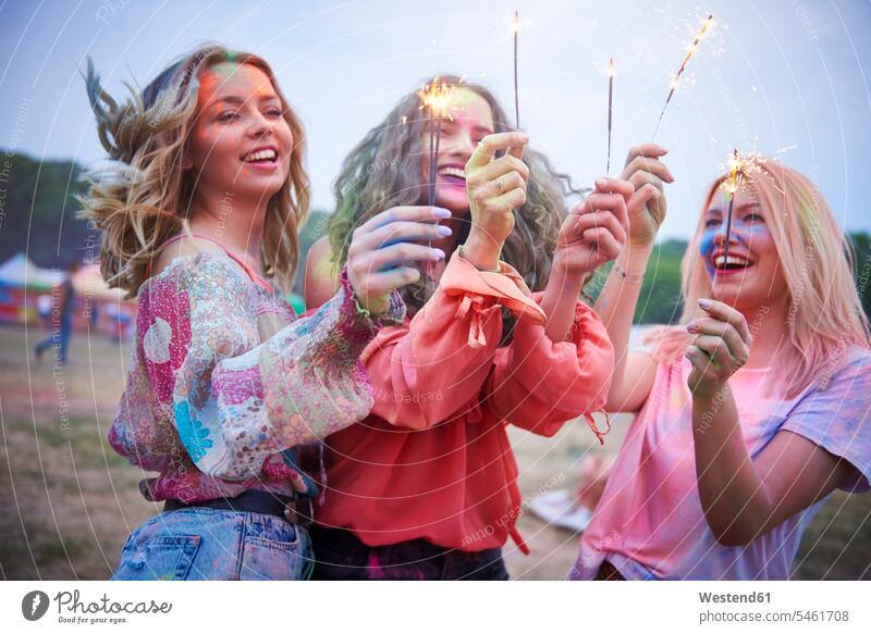 Portrait of friends with sparkler at music festival female friends powder powders dancing dance music festivals sparklers portrait portraits exuberance hilarity