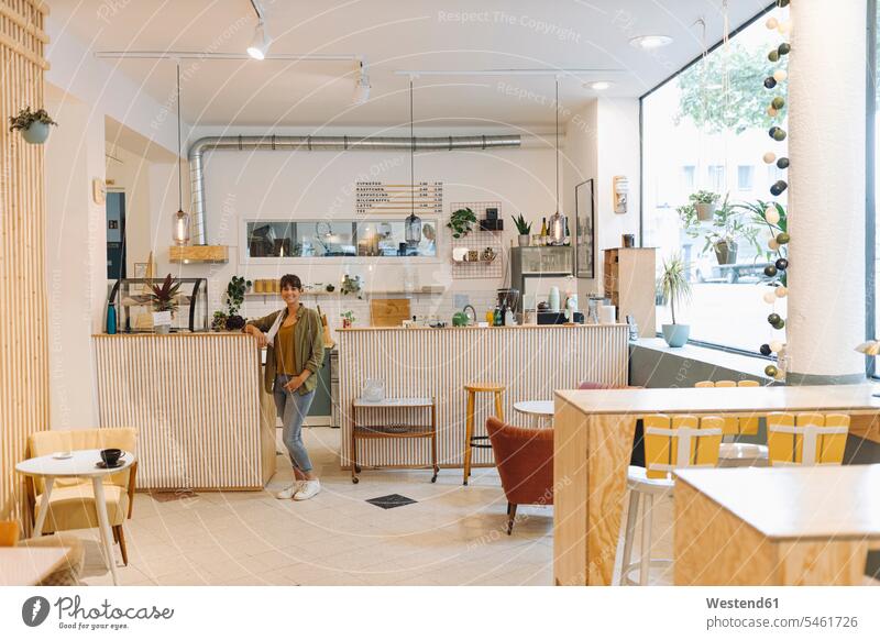 Businesswoman standing near counter in cafe color image colour image indoors indoor shot indoor shots interior interior view Interiors day daylight shot