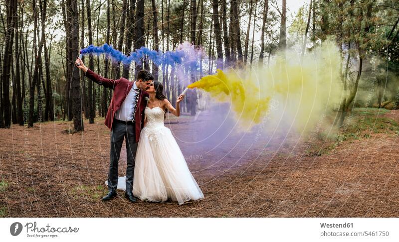 Bride and groom kissing in forest holding smoke torches bride brides woods forests Wedding getting married marrying Marriage smoking torch bridal couple
