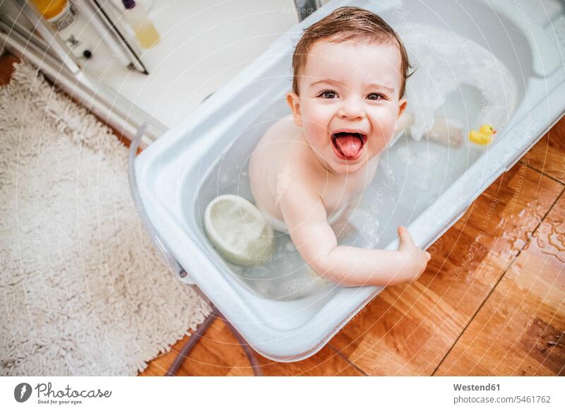 Portrait of baby boy in bathtub sticking out tongue bath tub bath tubs bathtubs plastic bathe Taking A Bath relax relaxing relaxation delight enjoyment Pleasant