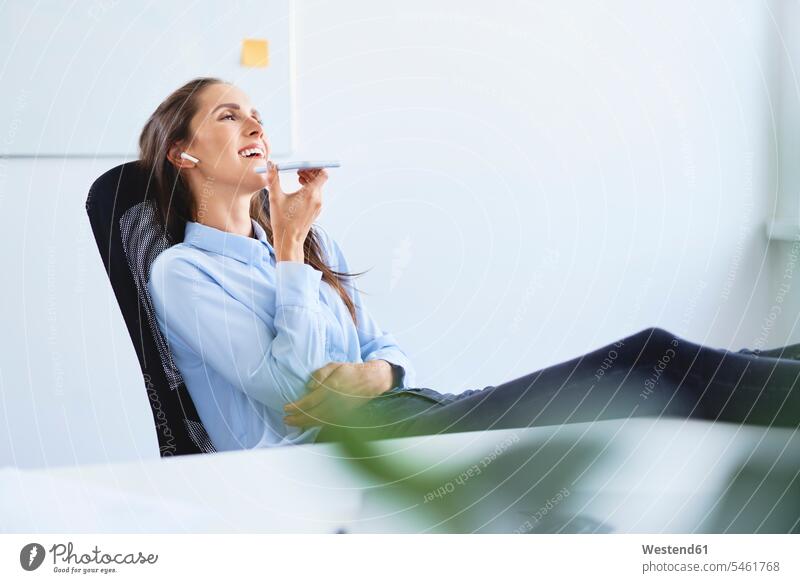 Cheerful businesswoman reclining in chair talking on phone human human being human beings humans person persons caucasian appearance caucasian ethnicity