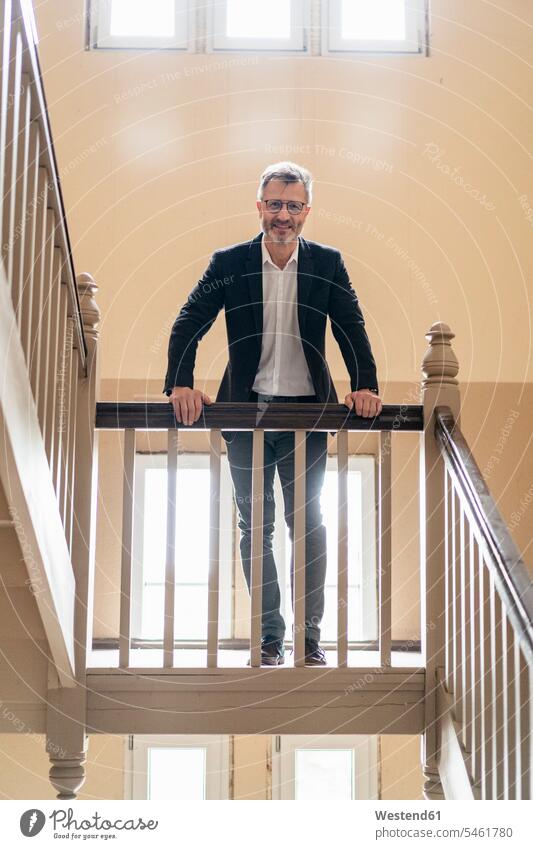 Portrait of smiling businessman standing in the stairwell smile Businessman Business man Businessmen Business men staircase staircases portrait portraits