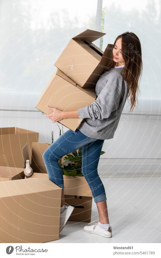 Woman carrying cardboard boxes in new home Cardboard Carton carton Cardboards cartons apartment flats apartments woman females women at home moving house move