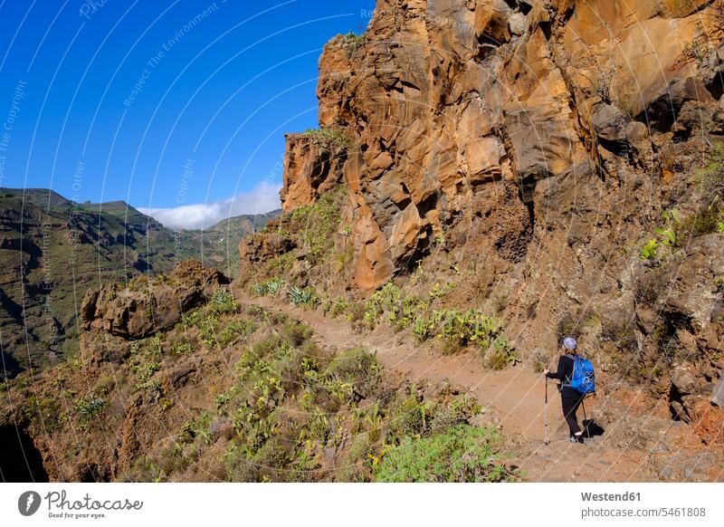 Spain, Province of Santa Cruz de Tenerife, San Sebastian de La Gomera, Rear view of senior backpacker hiking at Alto de Tacalcuse outdoors location shots