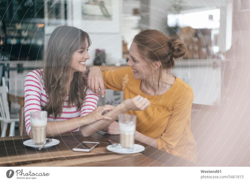 Two girlfriends meeting in a coffee shop, talking female friends cafe encounter gathering speaking sitting Seated mate friendship confidence confident carefree