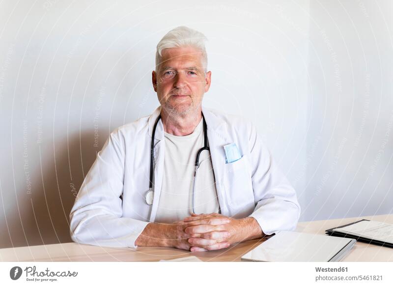 Doctor sitting against wall in clinic color image colour image indoors indoor shot indoor shots interior interior view Interiors day daylight shot