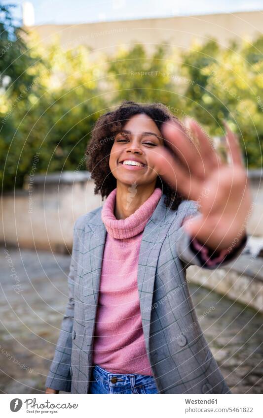 Portrait of laughing young woman raising hand females women Laughter portrait portraits human hand hands human hands Adults grown-ups grownups adult people