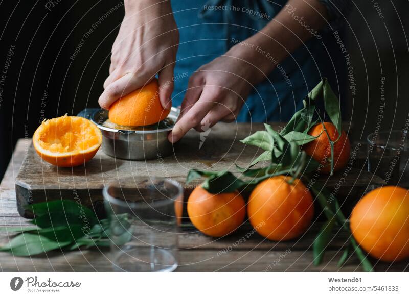 Young man's hands squeezing orange human hand human hands men males Orange Citrus sinensis Oranges young squeese squeezed people persons human being humans